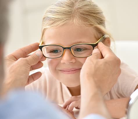 Young girl trying on glasses